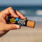 Sun Zapper Dark Skin Tone Zinc Stick in hand at beach, Sun Zapper Zinc Sticks, Dunedin New Zealand